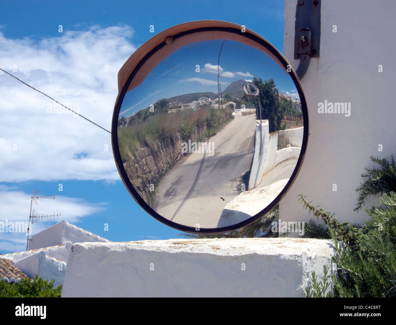 Un controbattitore specchio di sicurezza che mostra una strada in una zona residenziale di Javea, Spagna. Foto Stock