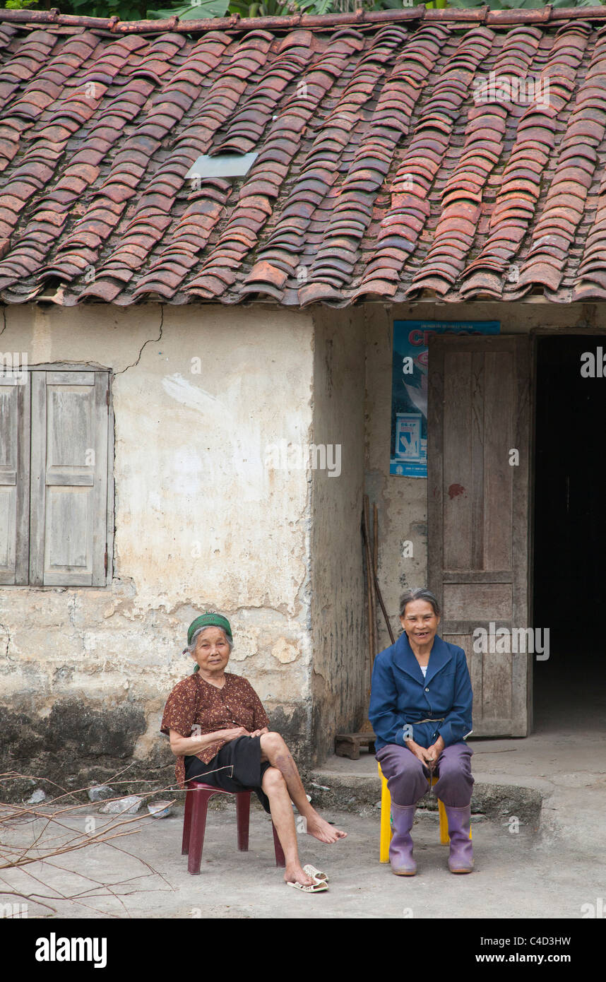Nord vietnamiti anziane donne contadine seduta al di fuori della loro casa rurale Foto Stock