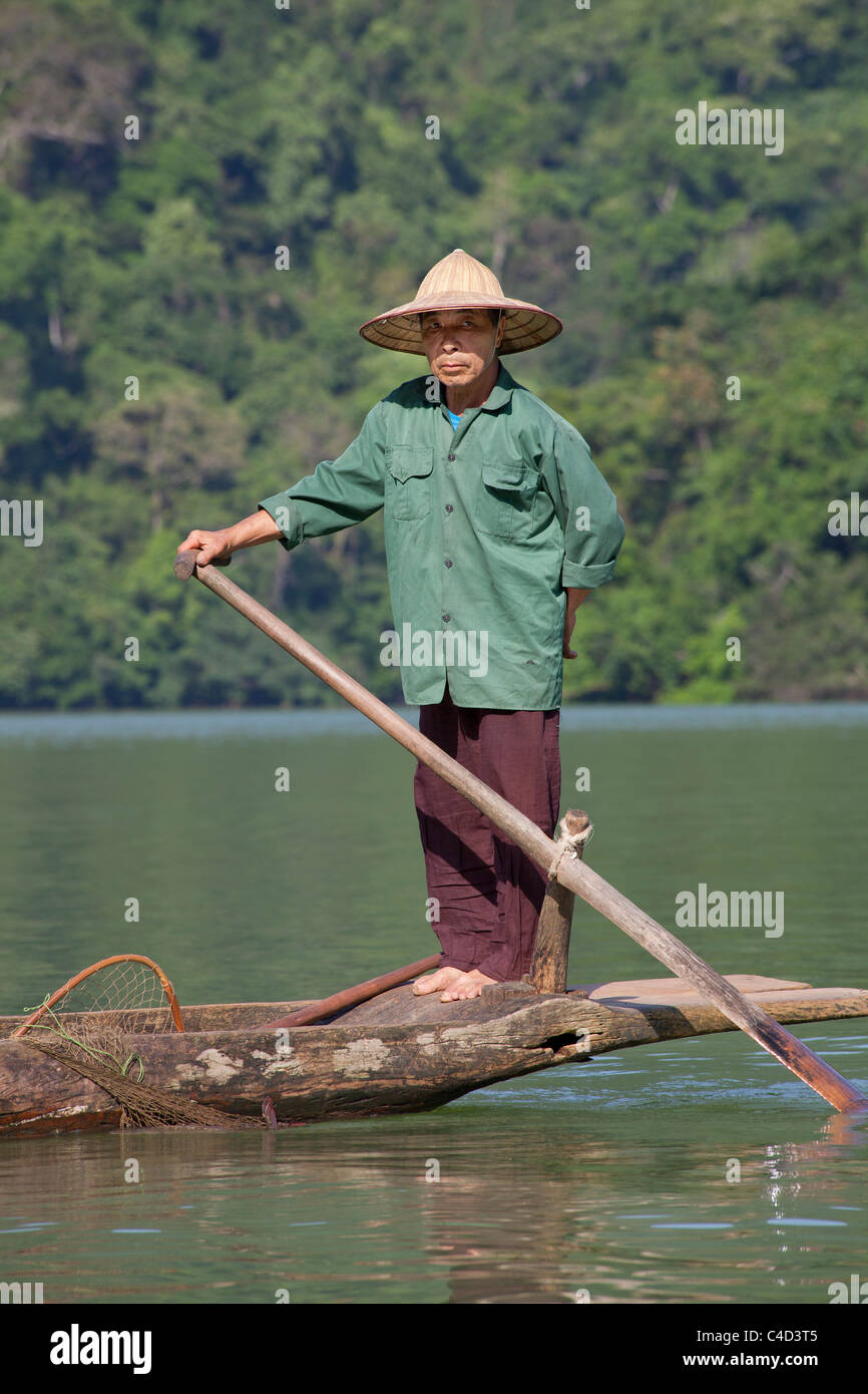 Pescatore vietnamita in un sampan, Ba essere Lake National Park, Nord Vietnam Foto Stock