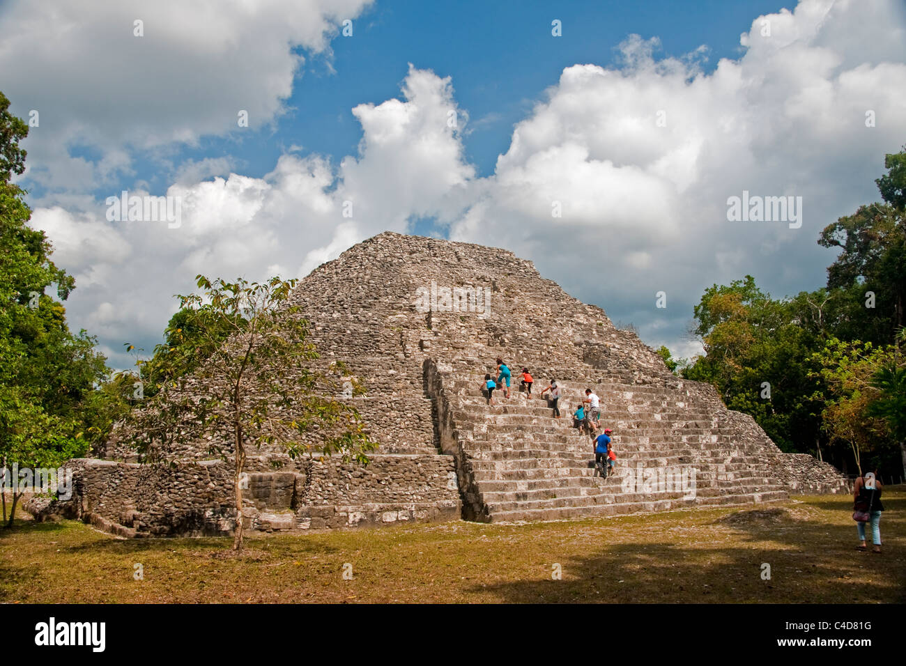 I turisti climbing tempio Maya di rovina di Yaxha in Guatemala Foto Stock