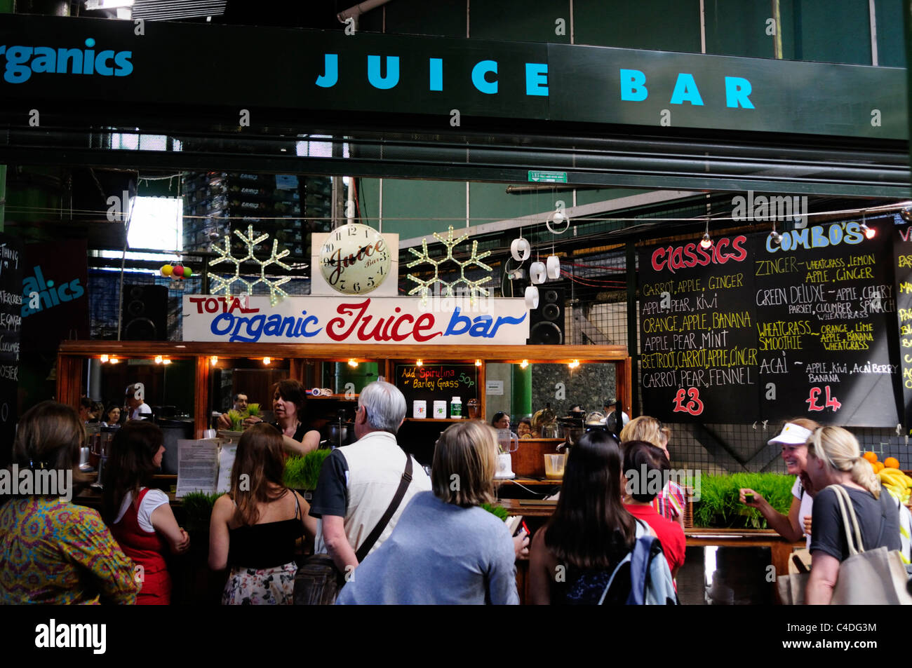 Le persone a un organico di un bar con succhi a Borough Market, Southwark, Londra, Inghilterra, Regno Unito Foto Stock