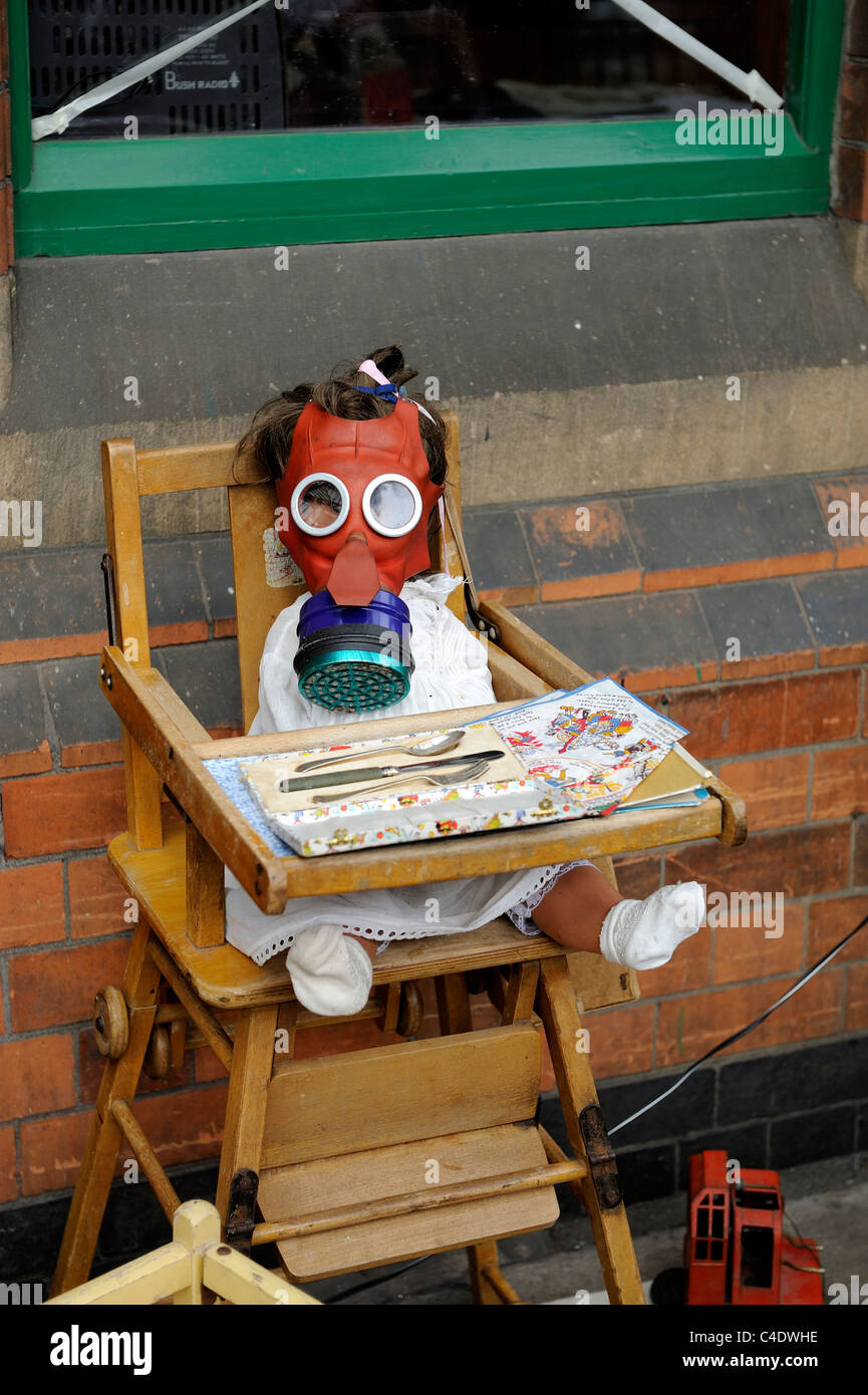 Tempo di guerra il display della bambola indossa una maschera a gas seduto in una sedia bambino loughborough England Regno Unito Foto Stock