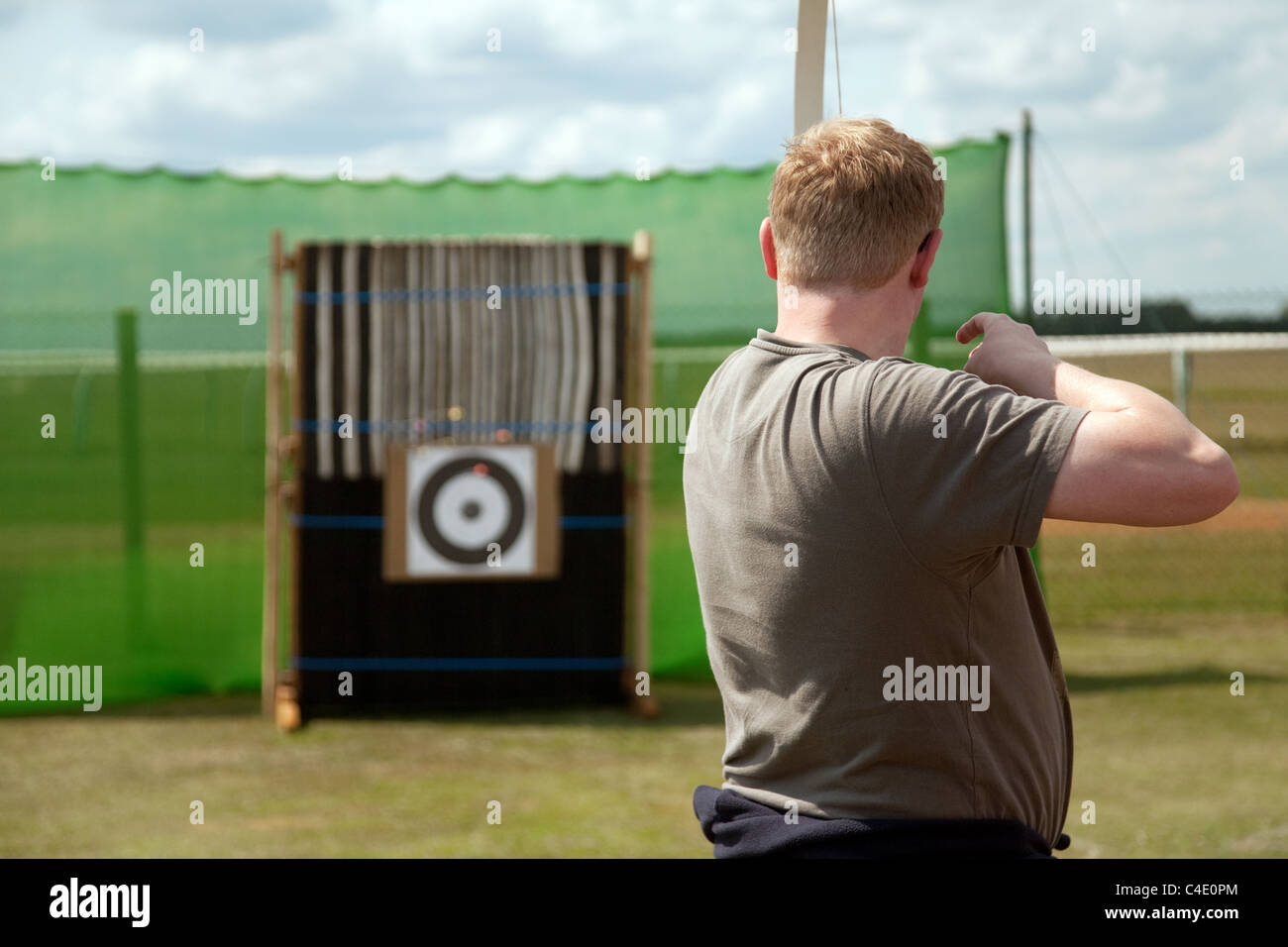Un uomo sovrappeso a sparare contro un bersaglio con arco e frecce Foto Stock