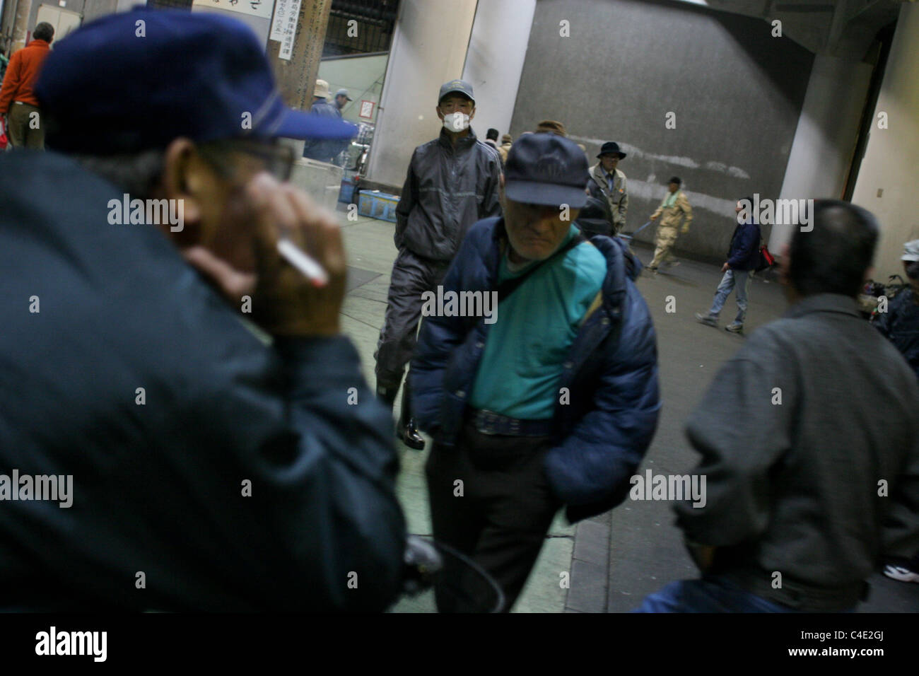 Disoccupati senzatetto uomini di andare in un rifugio per la notte in 'day mercato del lavoro " area di Kamagasaki, Osaka, Giappone. Foto Stock