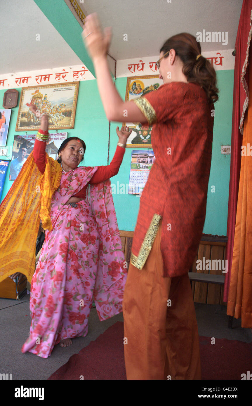 Un western woman dancing con una vecchia donna nepalese Foto Stock