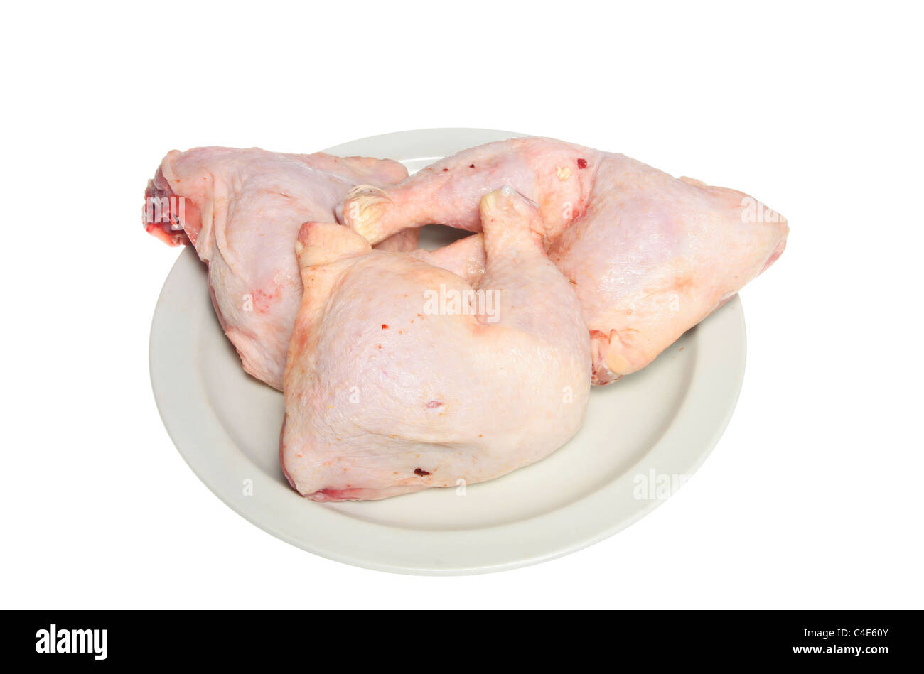Tre materie le cosce di pollo su una piastra bianca Foto Stock