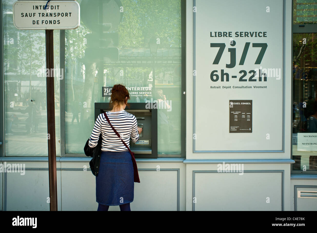 Donna distribuire contanti presso uno sportello bancomat, Montmartre, Parigi Foto Stock