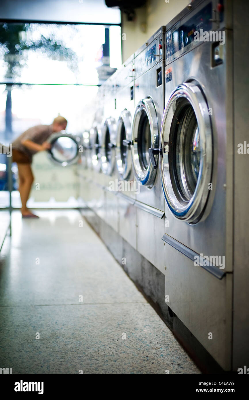 Giovane donna in lavanderia a gettoni Foto Stock