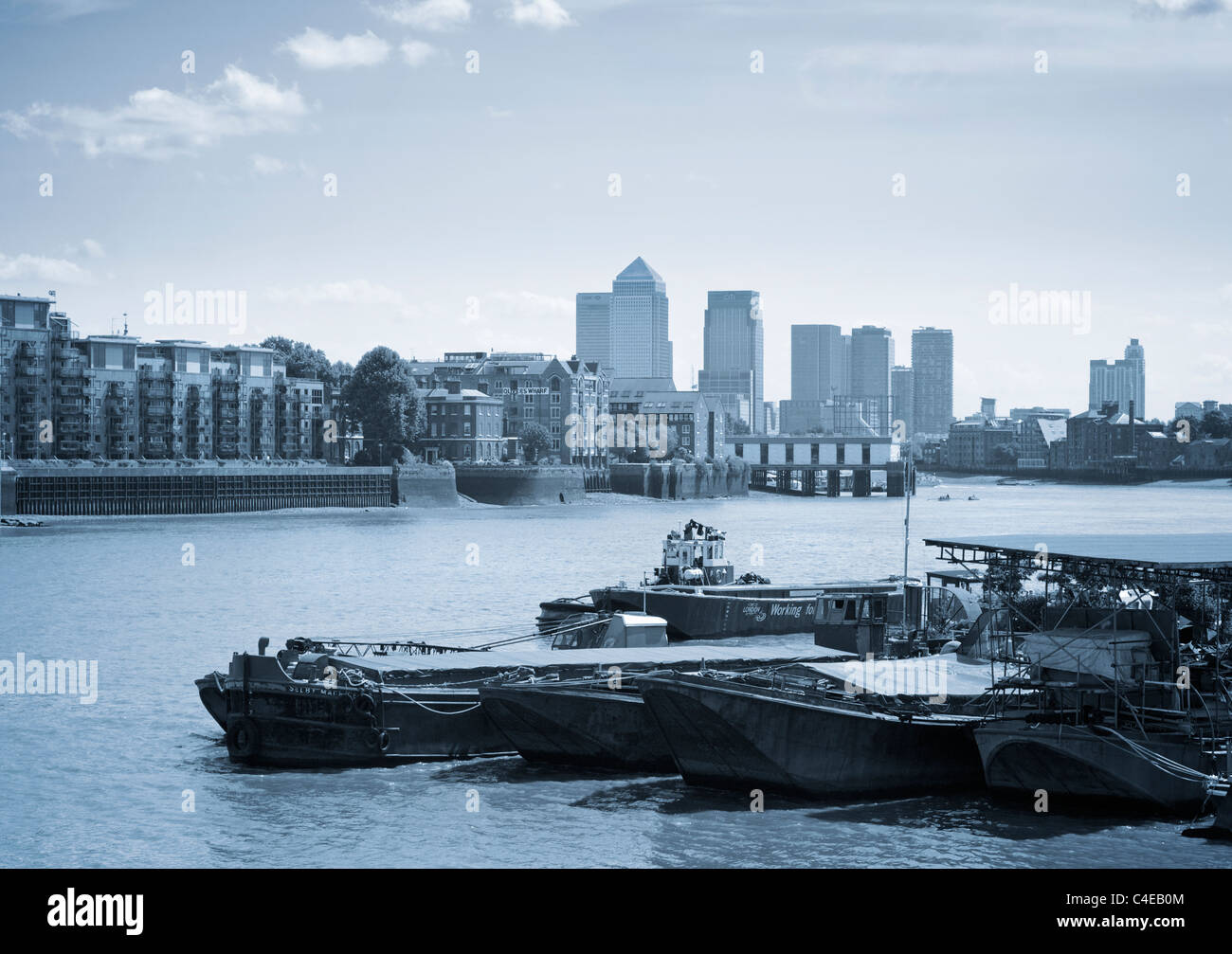 Vecchio chiatte ormeggiate su sul Tamigi e sul Canary Wharf sull'orizzonte di Londra, Regno Unito. Foto Stock