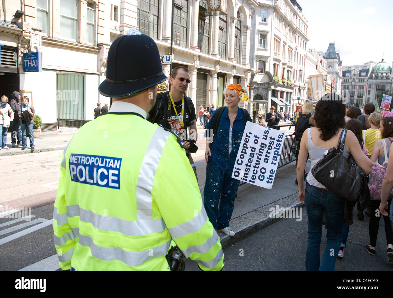 Un funzionario di polizia passeggiate lungo con manifestanti al rally slutwalk London Foto Stock