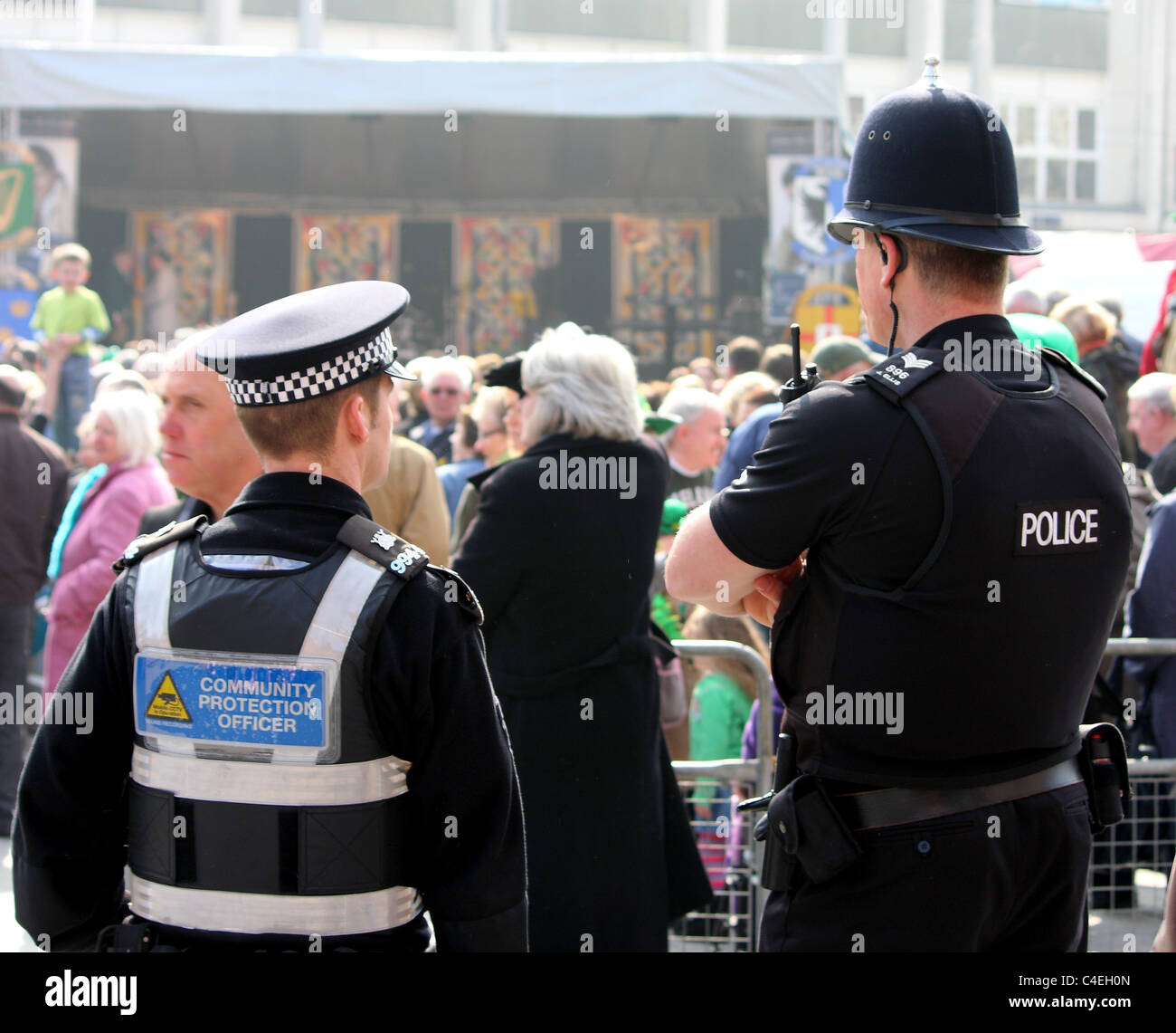 Uomo di polizia e di una protezione comunitaria officer presso un evento applicazione di controllo pubblico e di proteggere il pubblico generale Foto Stock