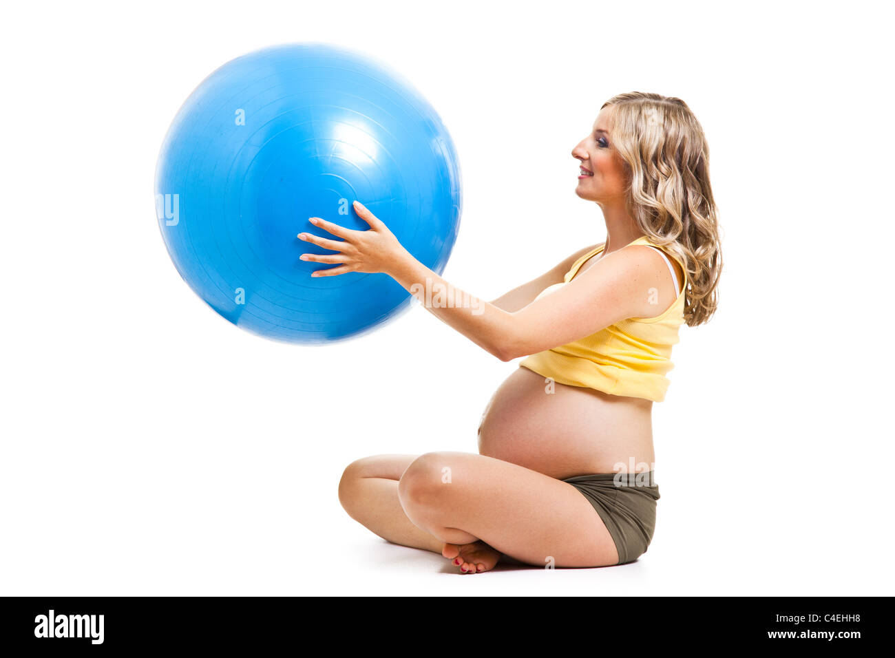 Bionda caucasica giovane adulto donna incinta di esercizi ginnici con big blue ball isolato su bianco Foto Stock