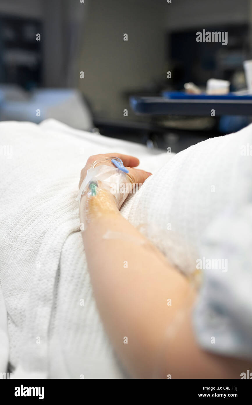 Chiusura del IV nella donna di braccio, stanza di ospedale letto. Winnipeg, Manitoba, Canada. Foto Stock