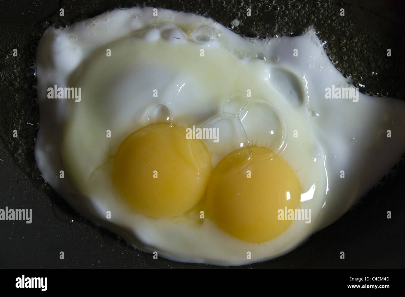 Fare doppio yolked di un uovo di gallina in padella Foto Stock