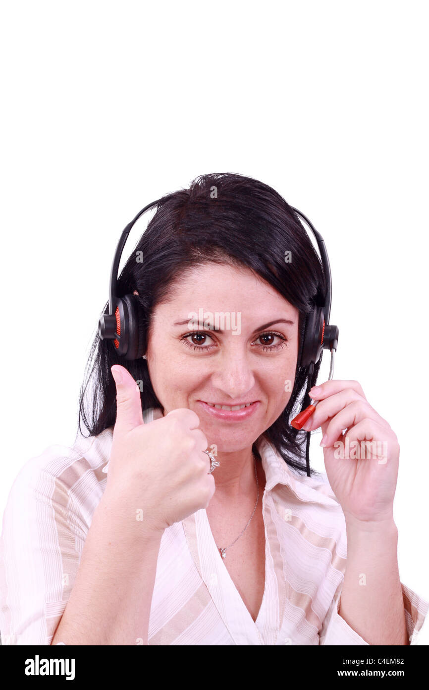 Sorridente call center giovane donna con una cuffia pollice in alto Foto Stock