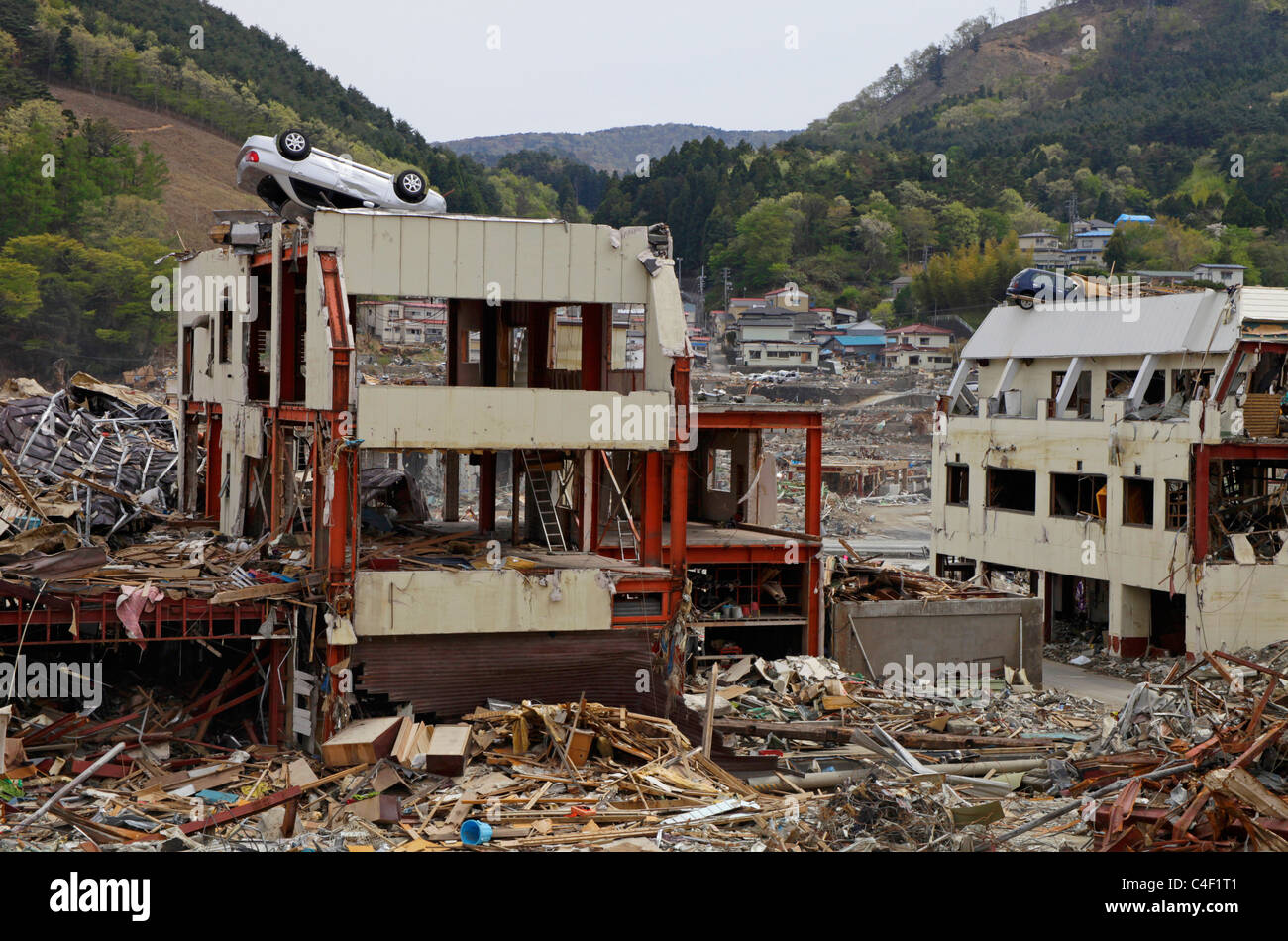Vetture a sinistra sulla sommità di edifici dopo il maremoto andato Onagawa town Miyagi Giappone Foto Stock