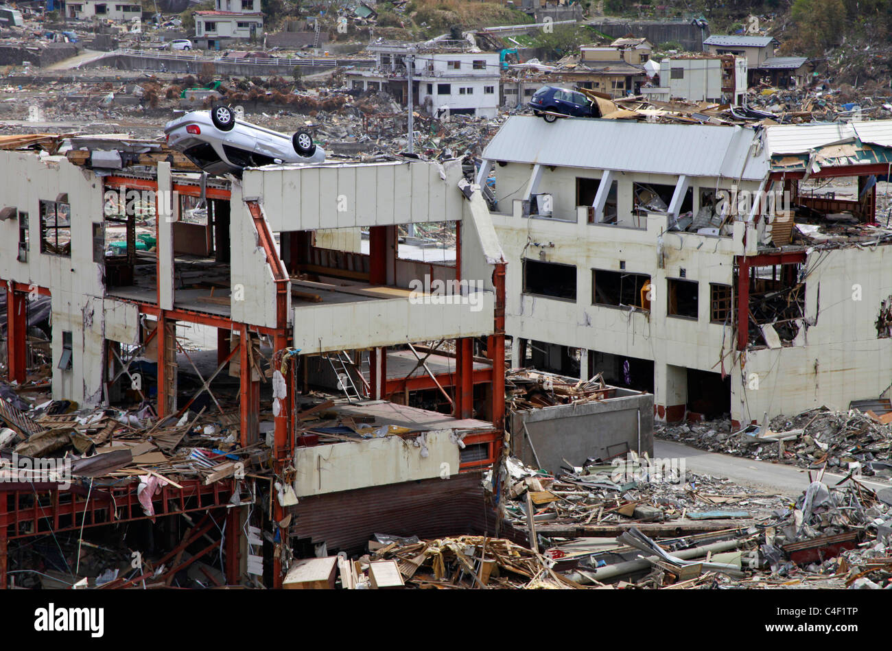 Vetture a sinistra sulla sommità di edifici dopo il maremoto andato Onagawa town Miyagi Giappone Foto Stock