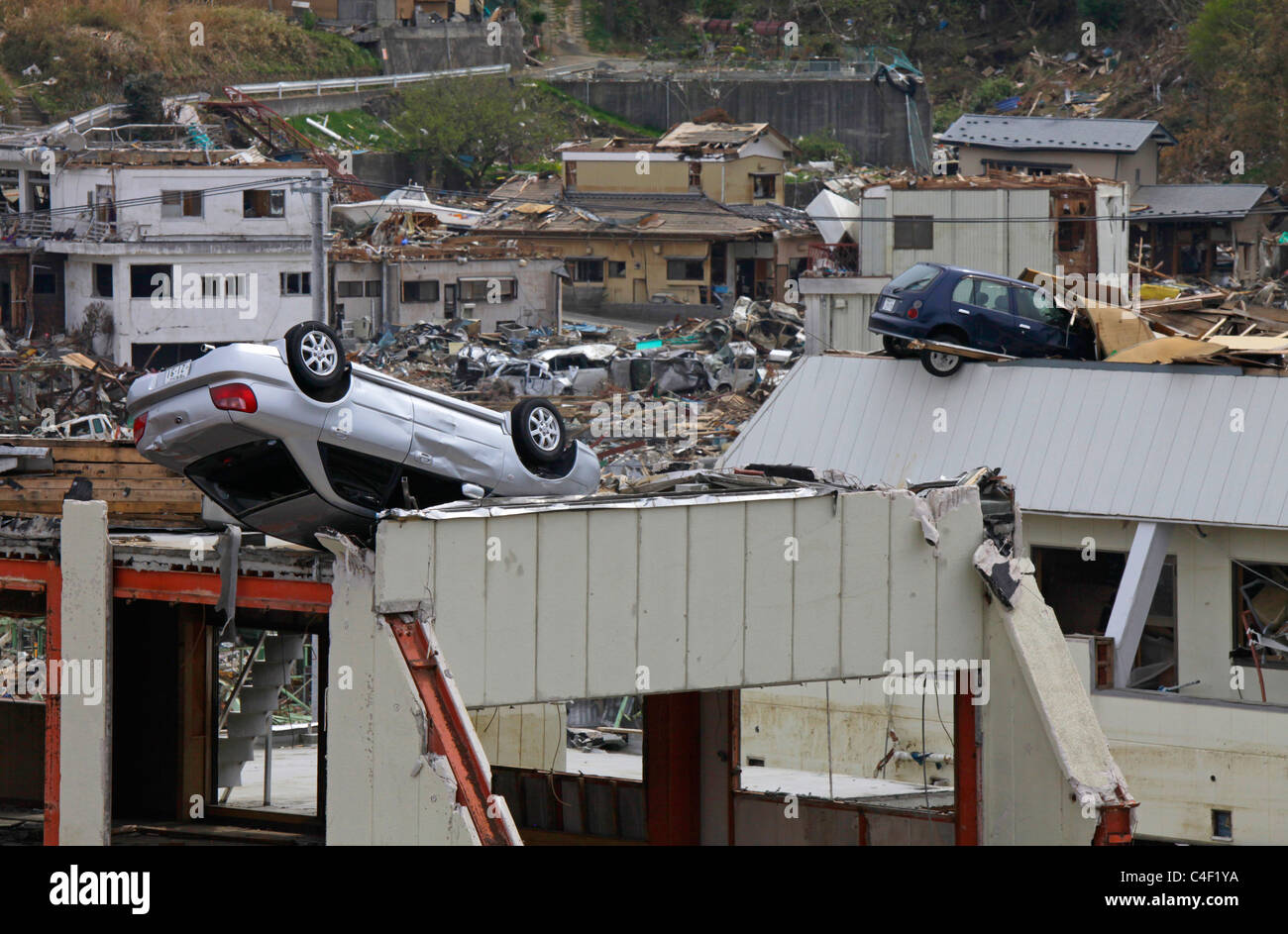 Vetture a sinistra sulla sommità di edifici dopo il maremoto andato Onagawa town Miyagi Giappone Foto Stock