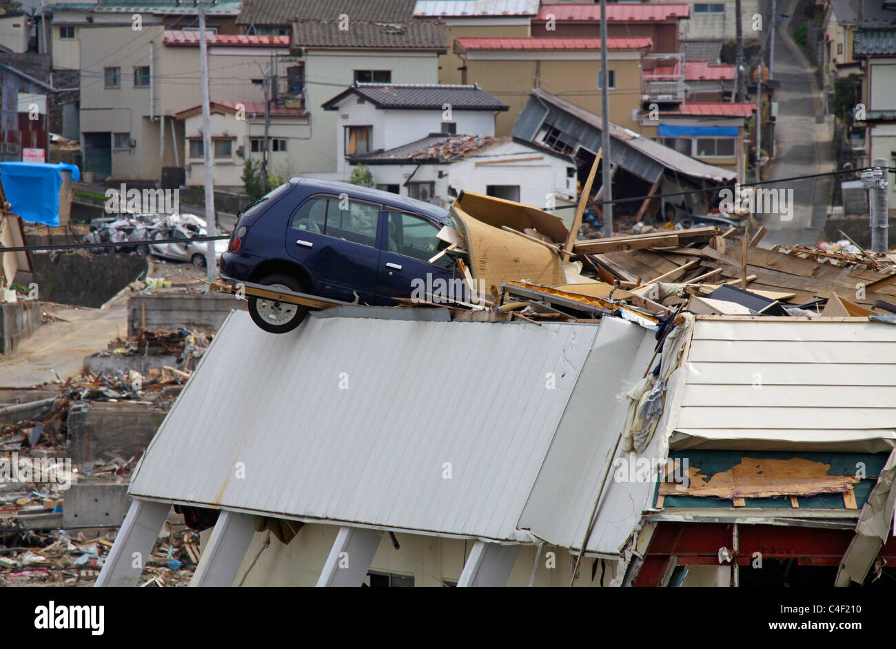 Un auto a sinistra sulla parte superiore di un edificio dopo il maremoto andato Onagawa town Miyagi Giappone Foto Stock