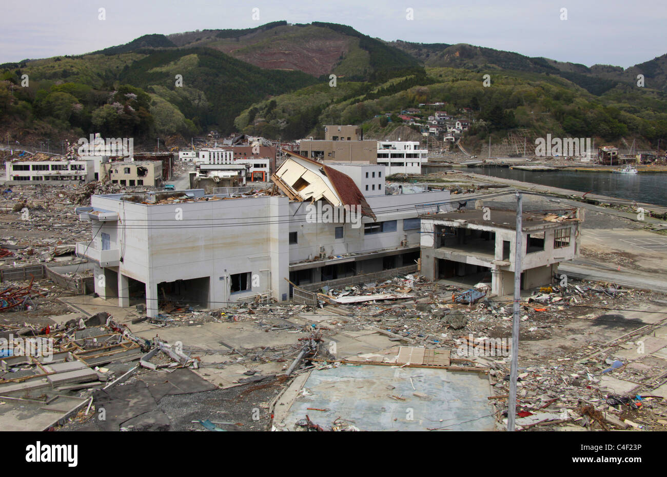 Una casa a sinistra sulla parte superiore di un edificio dopo il maremoto andato Onagawa town Miyagi Giappone Foto Stock