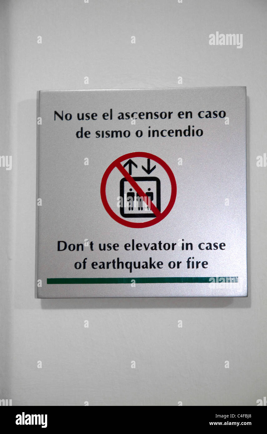 Segnale di avvertimento per ascensore in caso di terremoto in spagnolo e inglese a Lima, Perù. Foto Stock