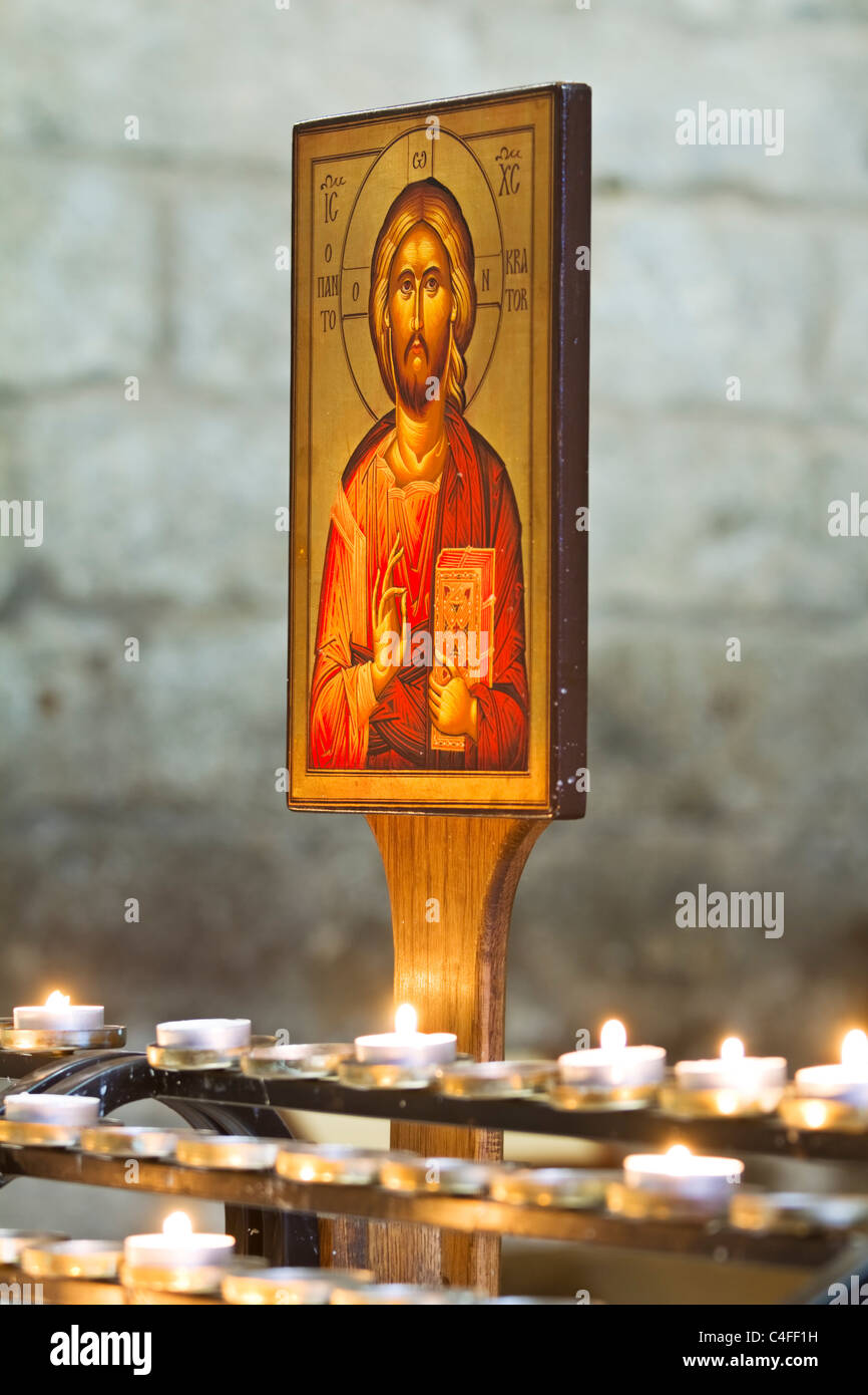 Un 'Europeo orientale' icona di stile di Gesù Cristo al di sopra di candele votive nella chiesa di Sant'Andrea in città Tynedale Hexham Foto Stock