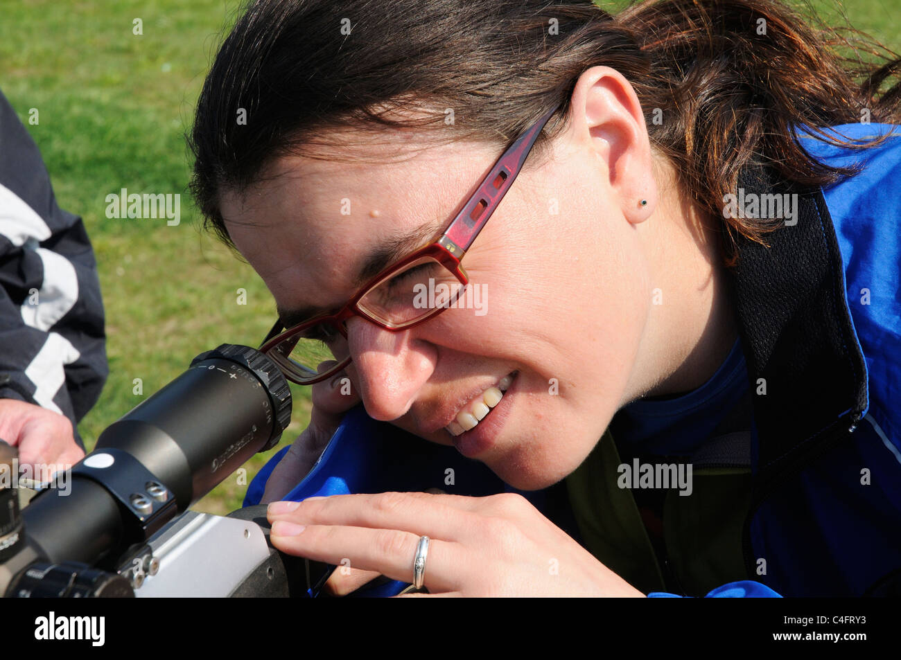 Una giovane donna che guarda attraverso i siti di un fucile ad aria compressa Foto Stock