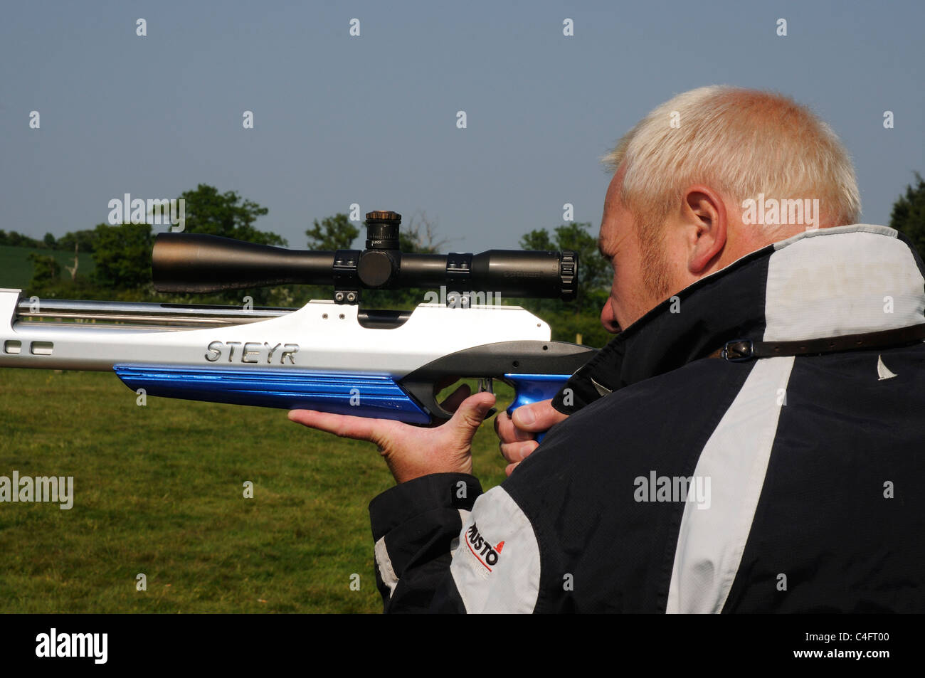 Un uomo che guarda attraverso i siti di un fucile ad aria compressa Foto Stock