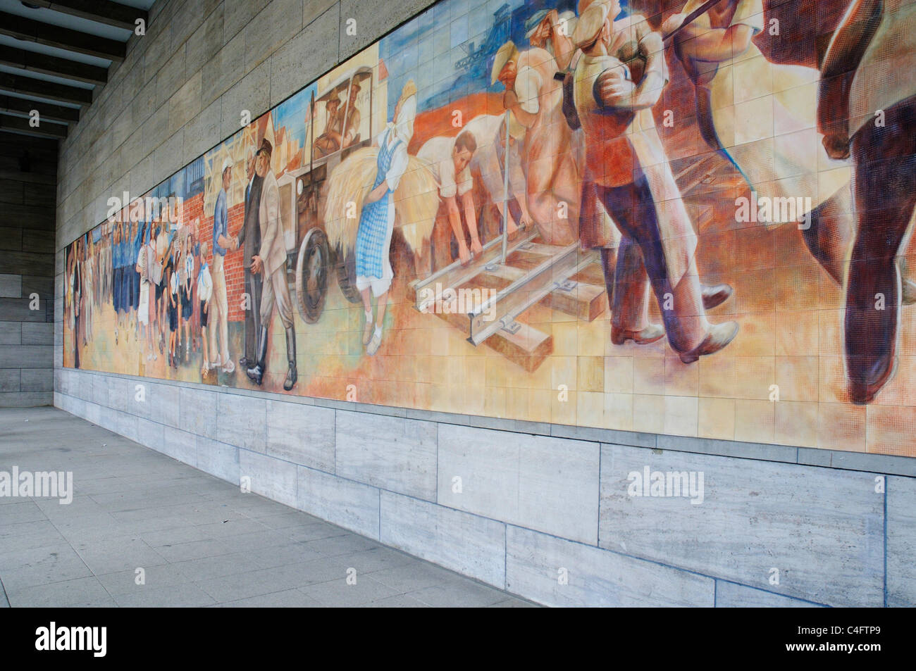 Parete socialista murale di felice i lavoratori sulla parete del ministero delle Finanze in edificio ex Berlino Est Foto Stock