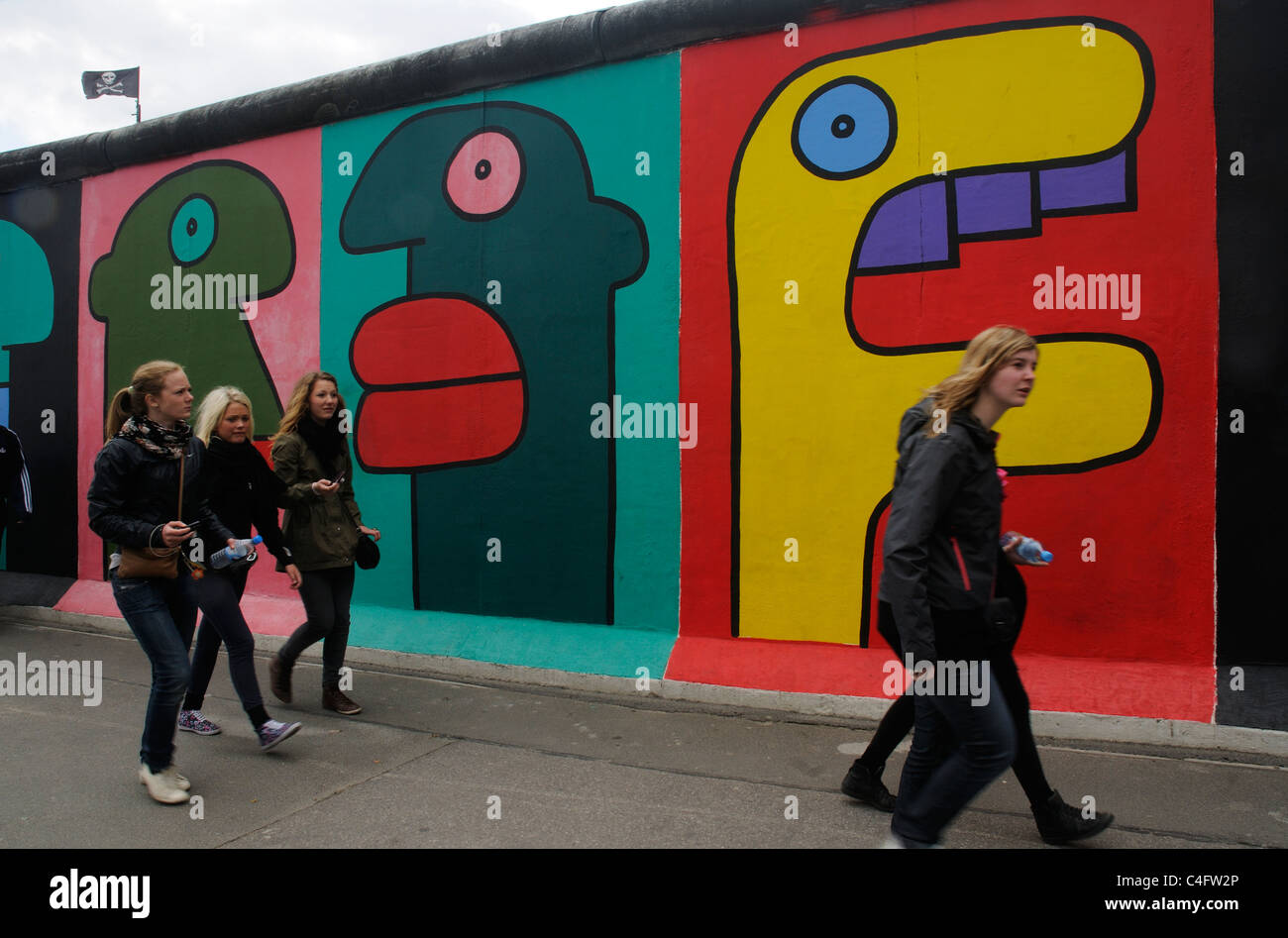 Un gruppo di persone a camminare lungo la East Side Gallery di Berlino Foto Stock