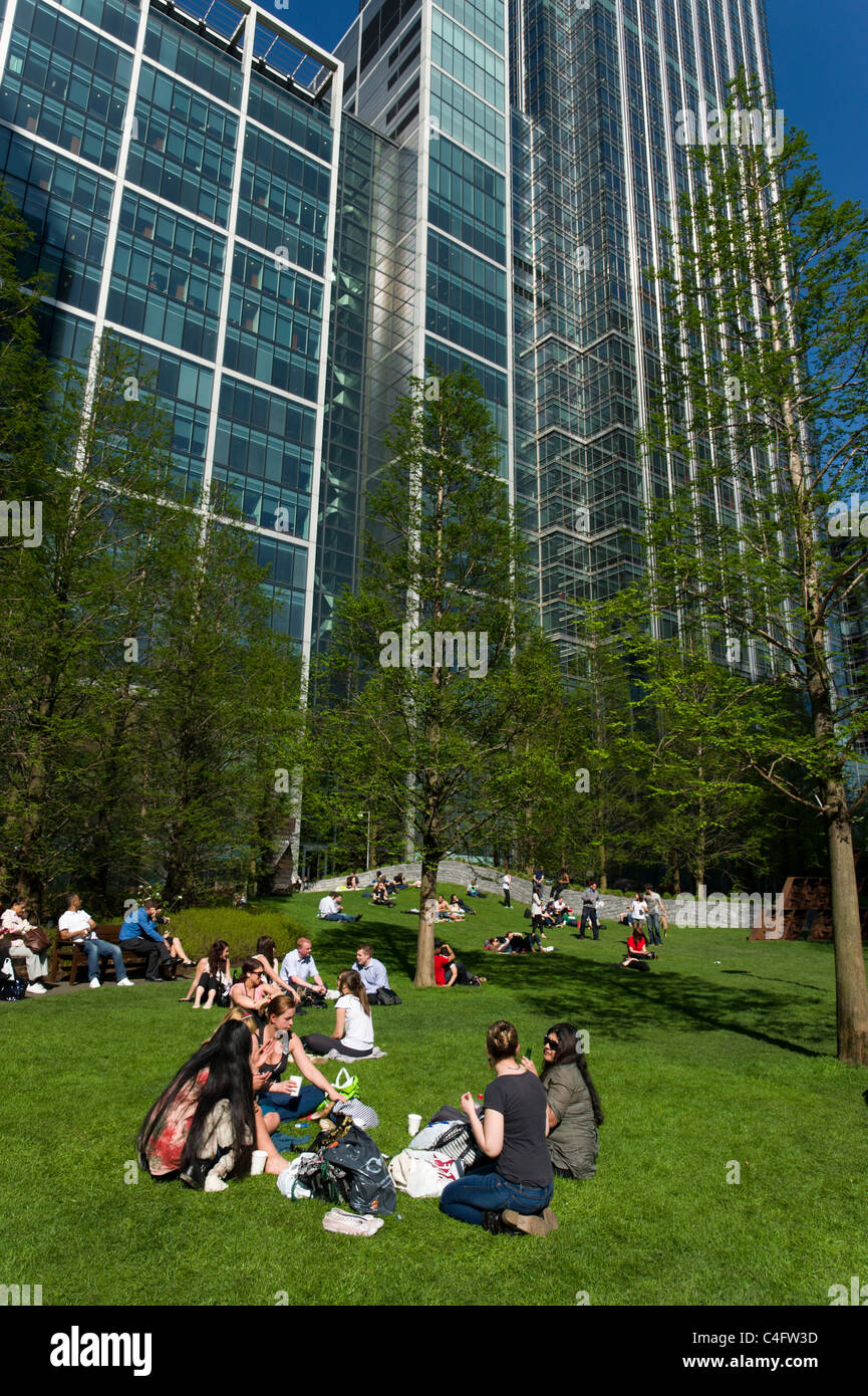 Ufficio i lavoratori aventi la loro pausa pranzo nel Parco del Cinquantenario, Canary Wharf, London, Regno Unito Foto Stock