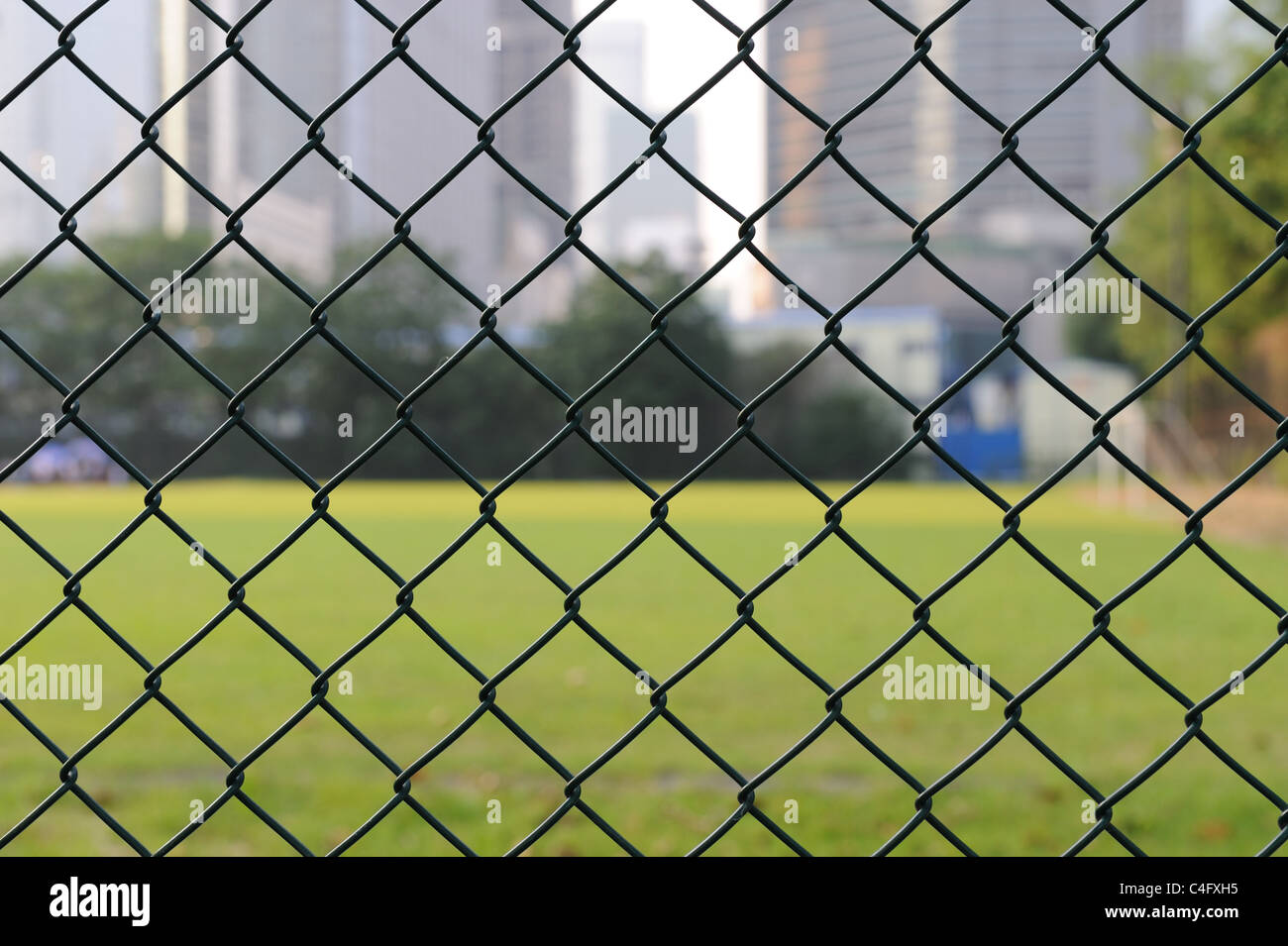 Rete metallica con campo di calcio come sfondo Foto Stock