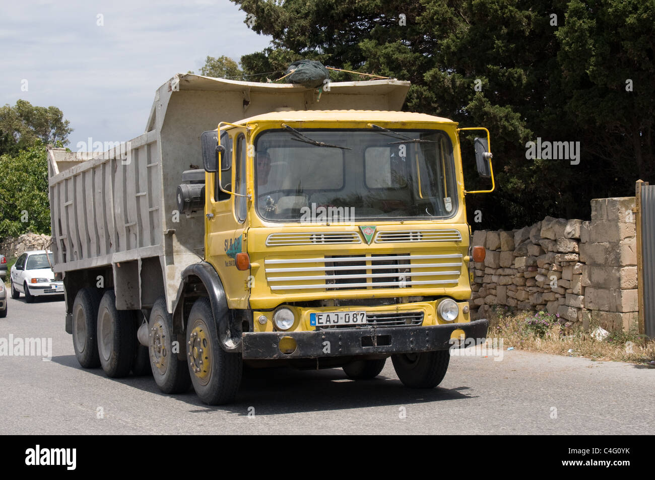 Un A.E.C assale quattro ribaltabile carrello procede lungo una strada Maltese per raccogliere il suo carico successivo. Foto Stock