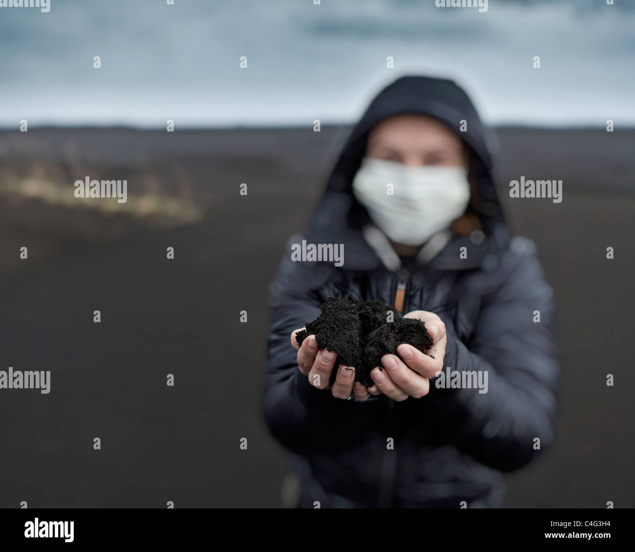 Donna nuova holding di cenere dal recente Grimsvotn eruzione vulcanica, Islanda Foto Stock