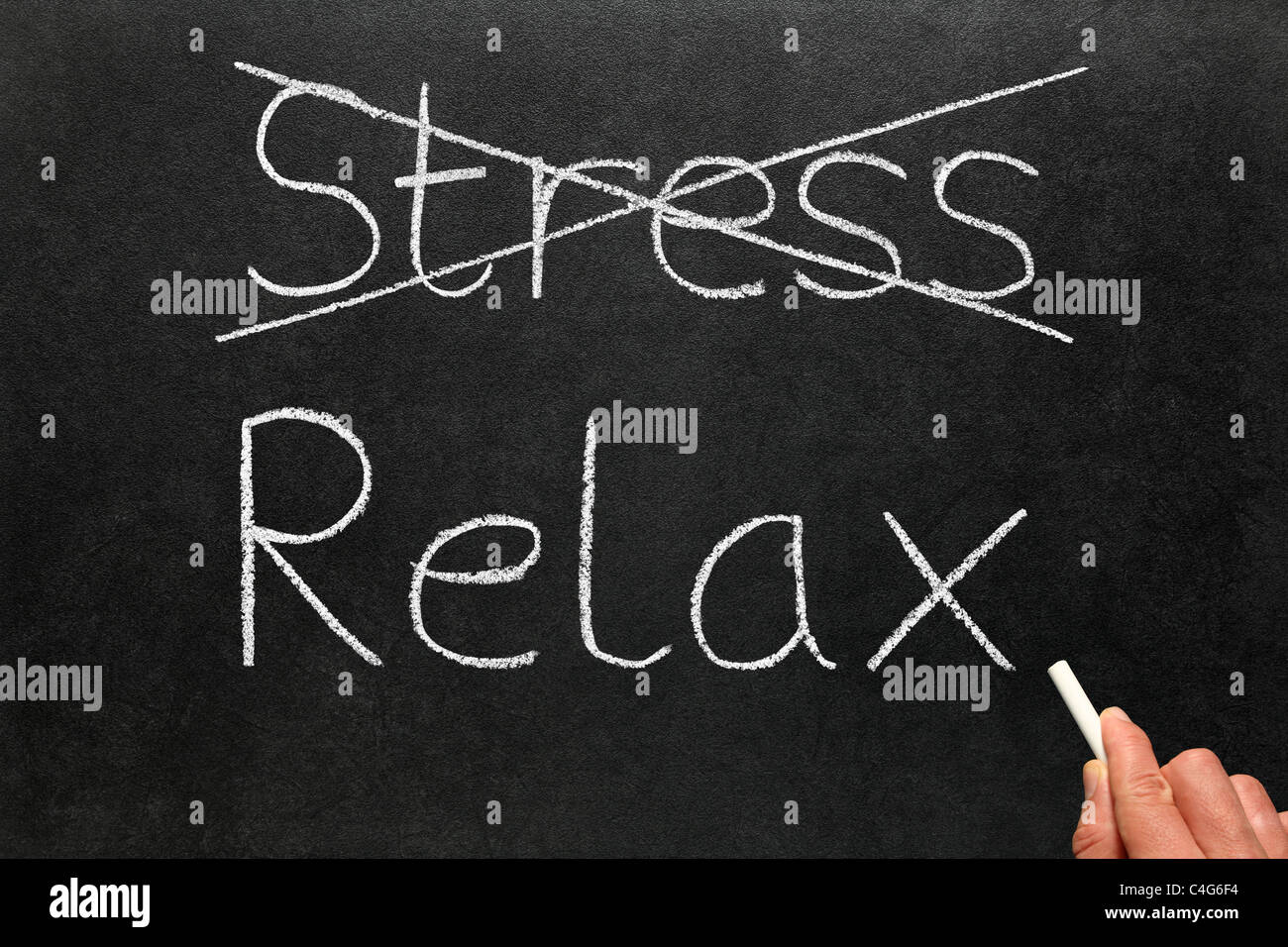 Attraversamento fuori lo stress e la scrittura di rilassarsi con il bianco gesso su una lavagna. Foto Stock