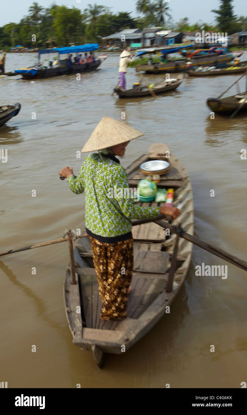 Una donna remare una barca sul fiume Mekong nr Can Tho, Vietnam Foto Stock