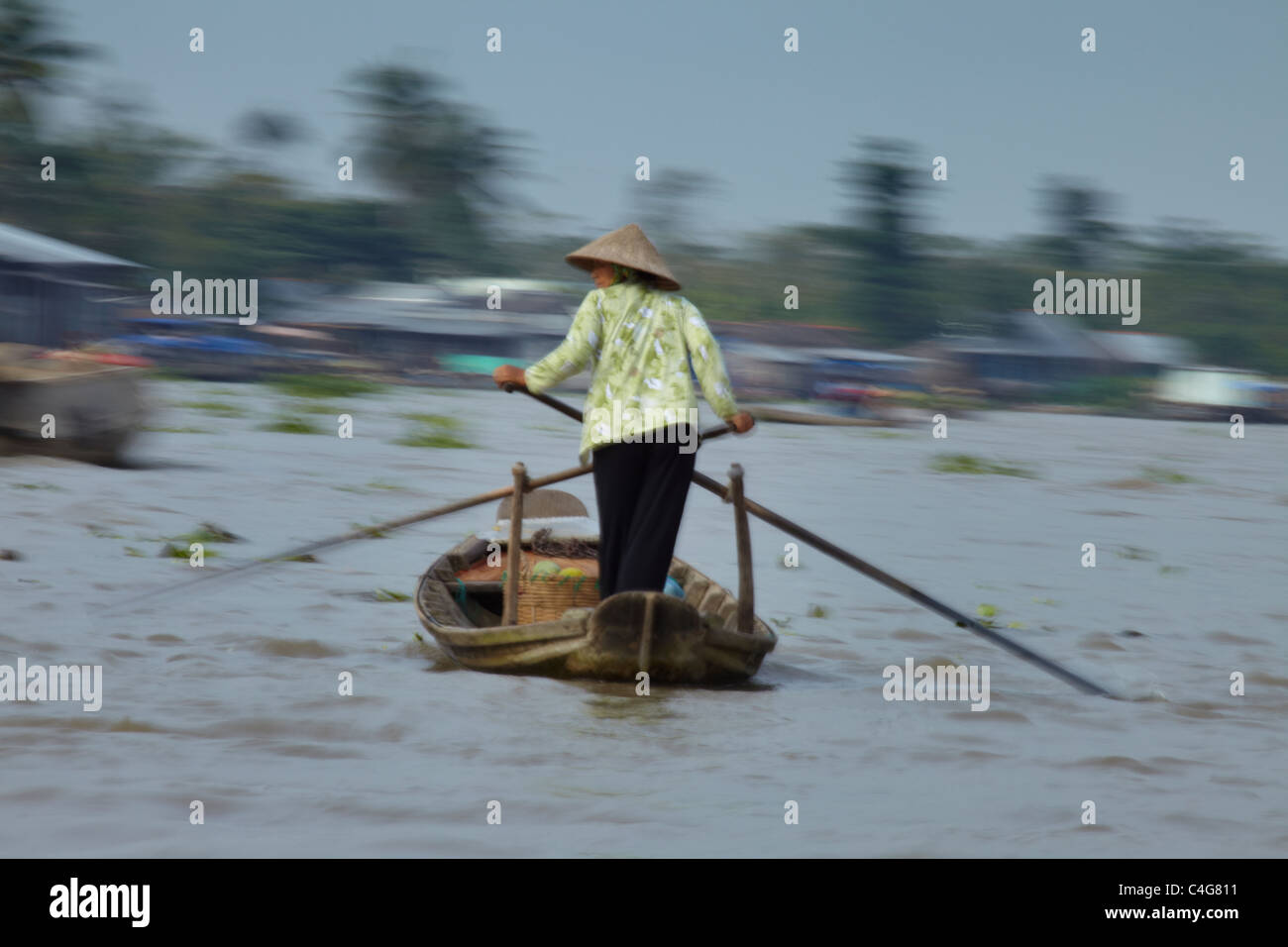 Una donna remare una barca sul fiume Mekong nr Can Tho, Vietnam Foto Stock