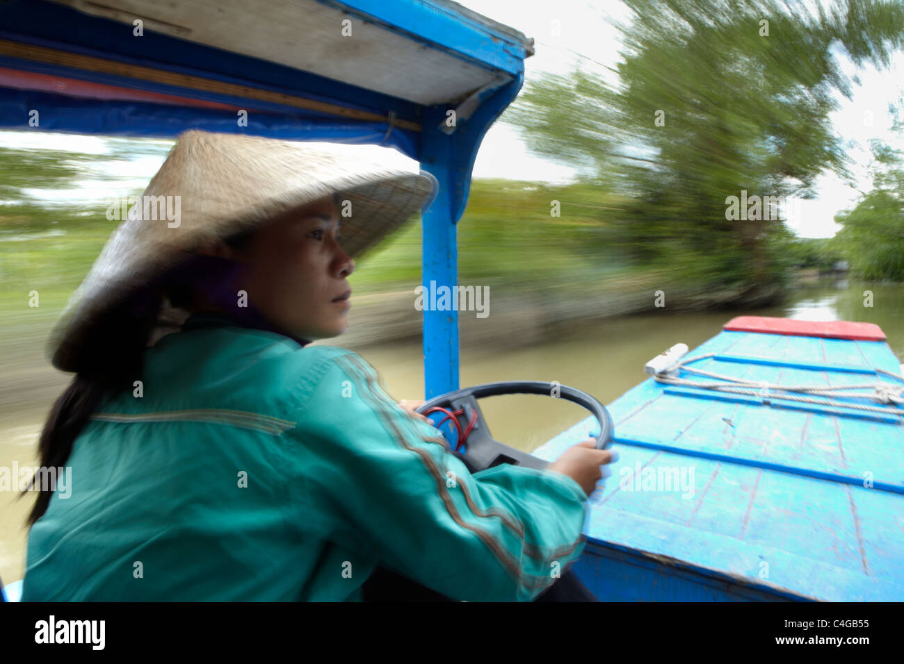 Una donna alla guida di una barca nr Can Tho, Delta del Mekong, Vietnam Foto Stock