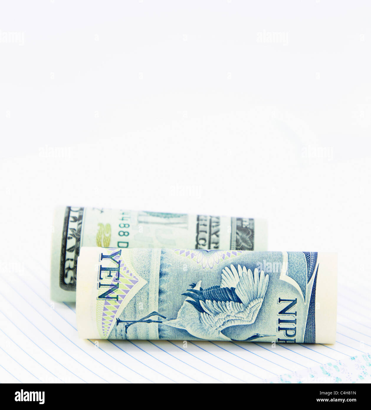 Su un notebook con pagine rigato, due valute al dollaro e allo yen, vengono posizionati insieme per chiudere l'immagine. Foto Stock