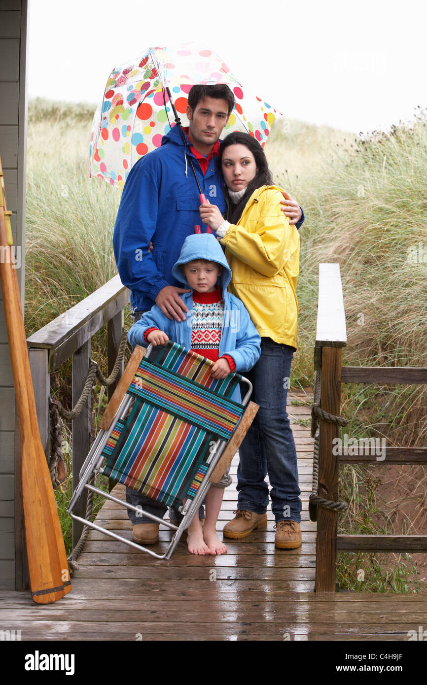 Famiglia sulla spiaggia con ombrellone Foto Stock