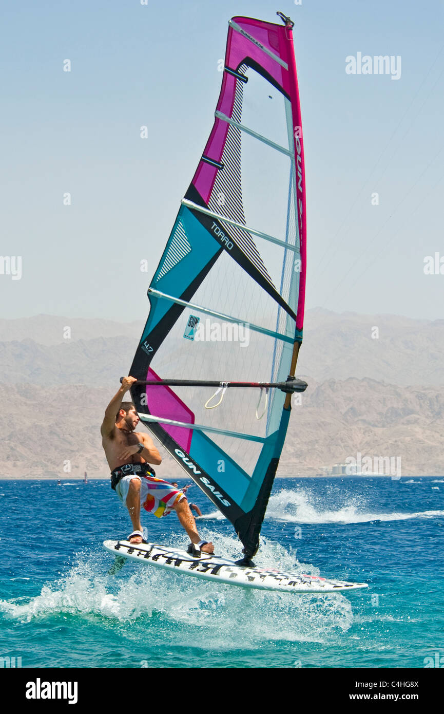 Un windsurf eseguendo acrobazie sul mar rosso presso il resort di Eilat in Israele. Foto Stock