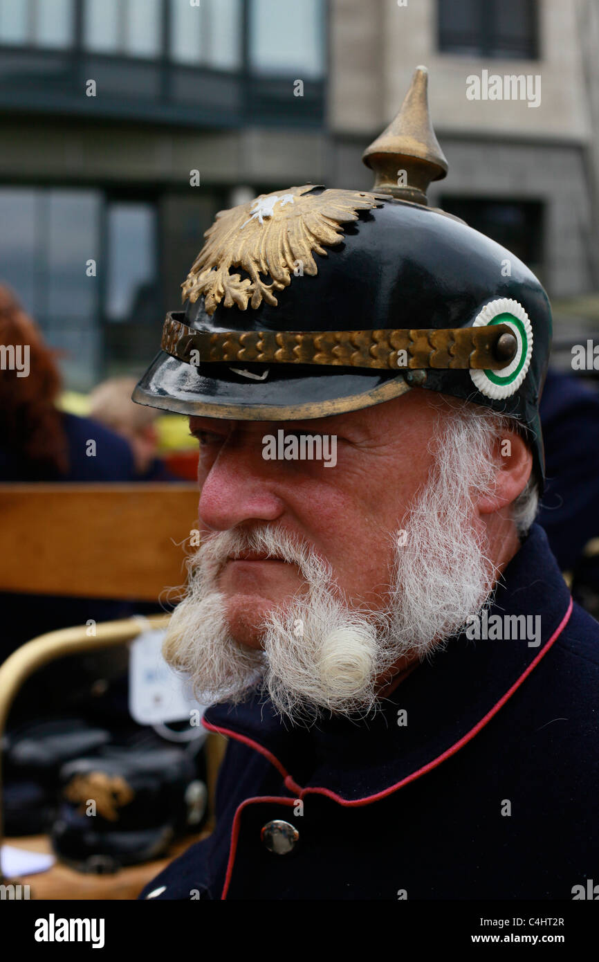 Uomo vestito come un ex pompiere indossa un casco spiked lo stile prussiano Pickelhaube o Pickelhelm copricapo in Leipzig Germania Foto Stock