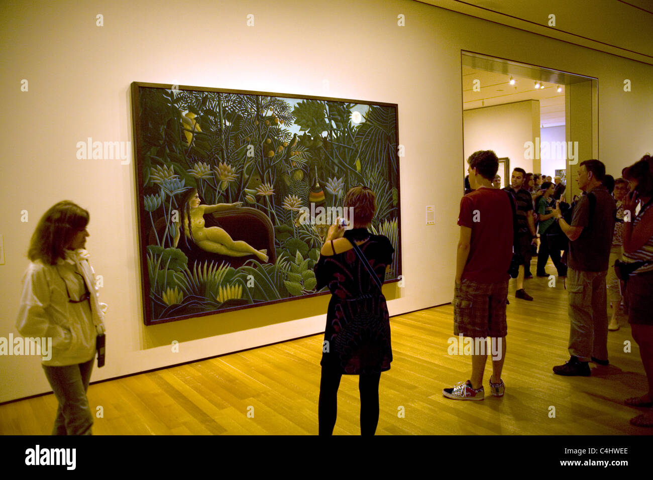 Arresto di visitatori dalla magica Henry Rousseau pittura, 'Il Sogno' presso il Museo di Arte Moderna di New York. Foto Stock