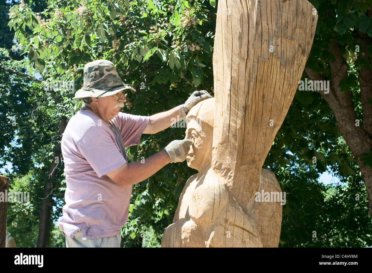Uno scultore crea una scultura in legno Foto Stock