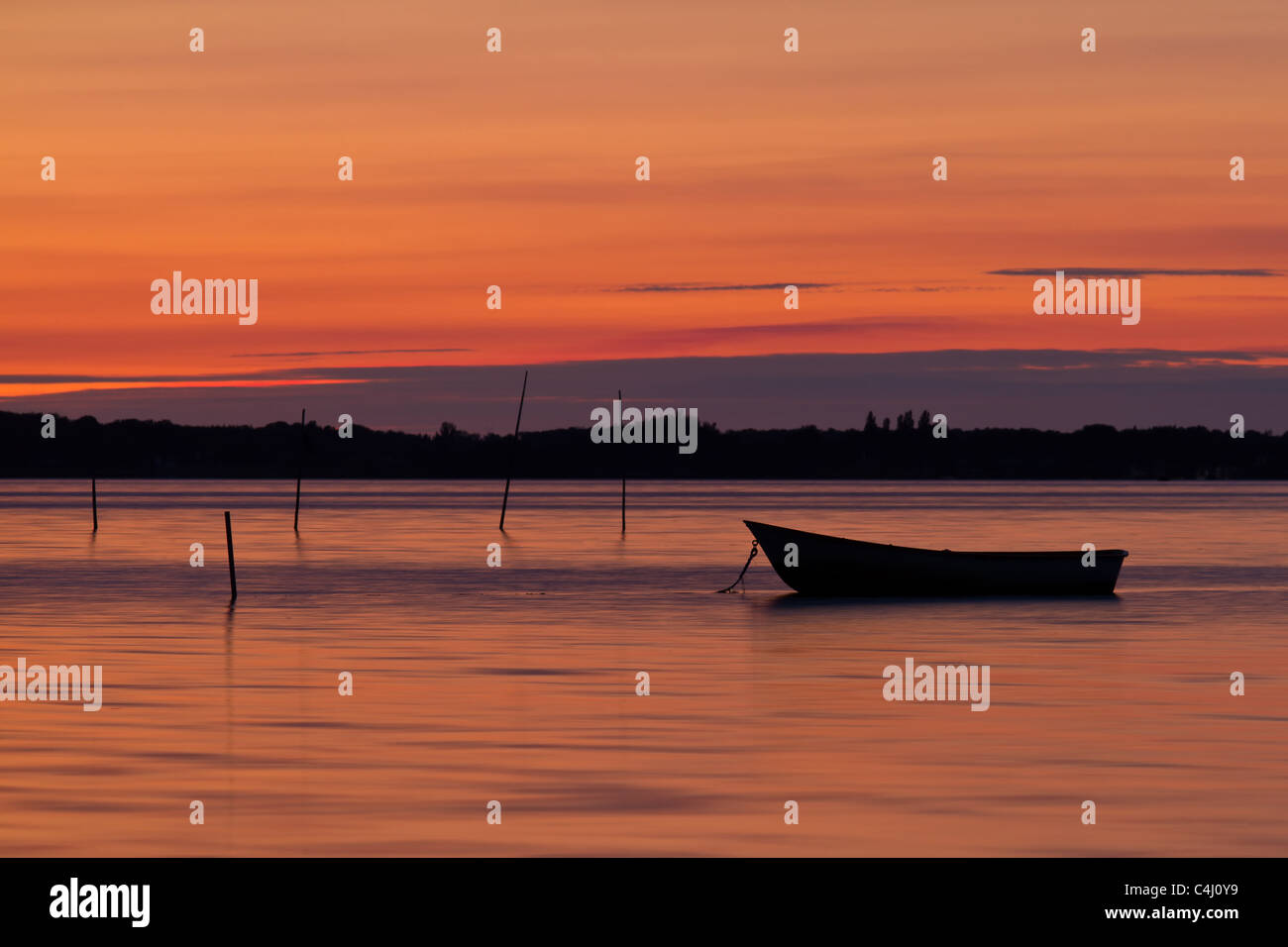 Vista panoramica della piccola pesca in barca al tramonto con cloudscape sfondo. Foto Stock