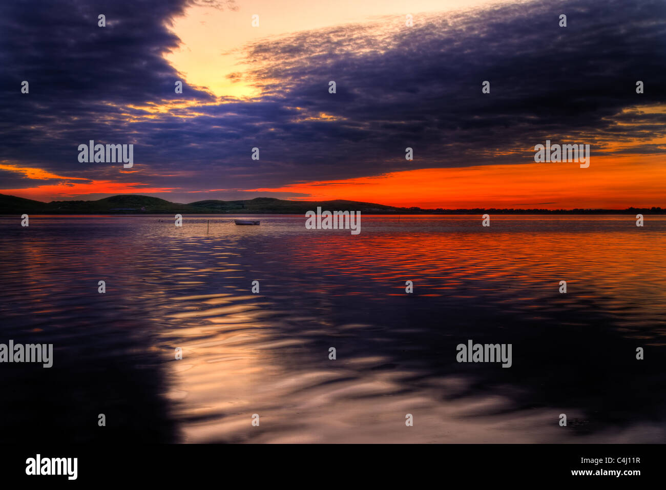 Vista panoramica della piccola pesca in barca al tramonto con cloudscape sfondo. Foto Stock