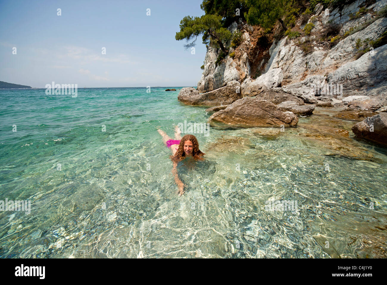 Giovane donna nuoto in acque chiare di Kastani Gialos Beach, Mamma Mia Posizione filmato su Skopelos Island, Grecia Foto Stock