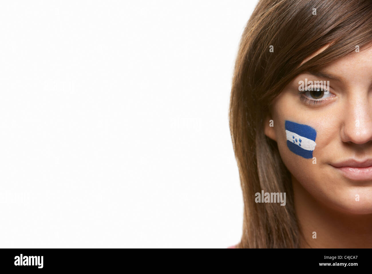 Giovani donne amanti dello sport con Honduras bandiera dipinta sul viso Foto Stock