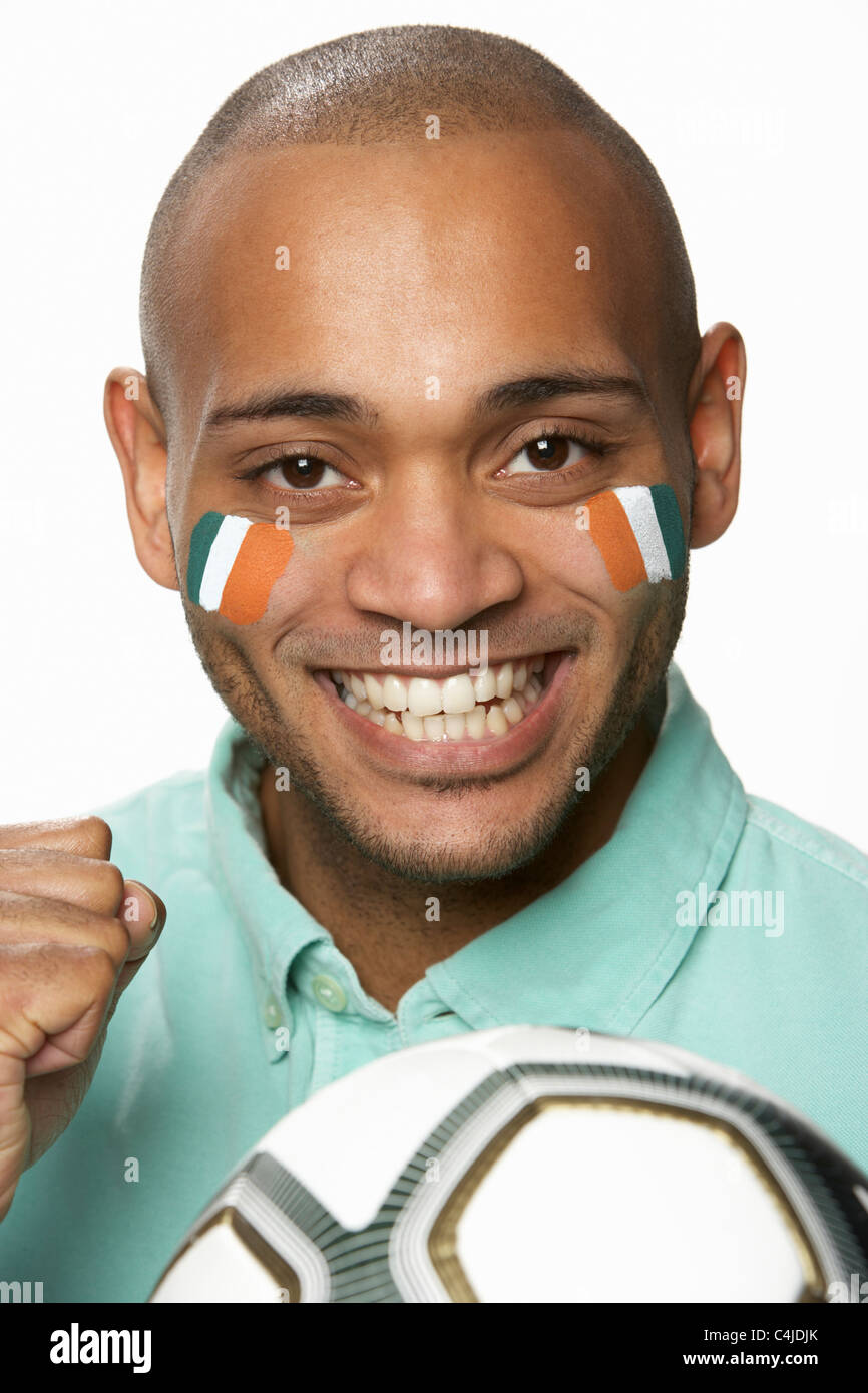 Giovane Maschio appassionato di calcio con la bandiera della Costa d'Avorio dipinto sul volto Foto Stock