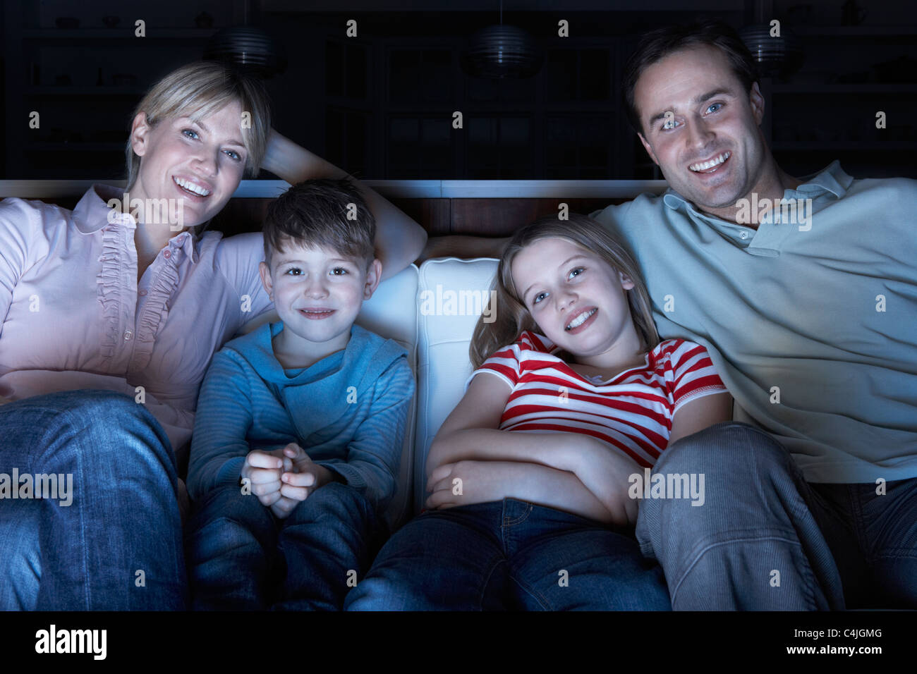 Famiglia di guardare la TV sul divano insieme Foto Stock